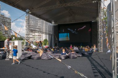 Moskova - 4 Ağustos 2018: rahatlatıcı ve yaz açık hava sinema Moskova Sineması projesi kapsamında farklı alanlarda Moskova'da kurmak çuval oturan filmi izlerken insanlar