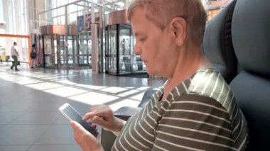 Holding ve iş alışveriş merkezinde modern smartphone kullanarak üst düzey kadın kapatın. Yaşlı insanlar ve modern teknoloji kavramı