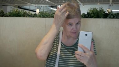 Üst düzey kadın saçlarını sabitleme smartphone aynada içine görünüyor