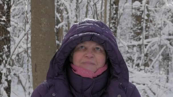 Starší žena s úsměvem a házení jiskřivý sníh do vzduchu — Stock video