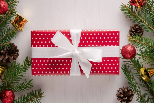 Boże Narodzenie prezent owinięty w czerwony papier z białe groszki i duży biały kokarda — Zdjęcie stockowe