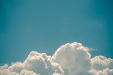 Turkuaz mavi gökyüzünde beyaz kabarık kümülüs bulutlar. Uzay kopyalayın. Vintage renkler. Arka plan ve duvar kağıdı için