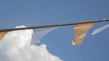 Festival bayrak mavi gökyüzü ve beyaz kabarık bulutlar karşı kiraz kuşu uçmaktan yakın çekim