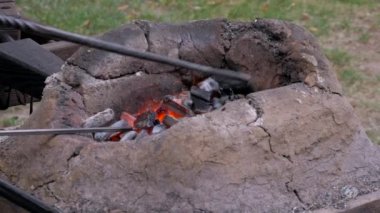 Ortaçağ fırın içinde yanan kömürlerin demirci forge metal araçları ile karıştırma