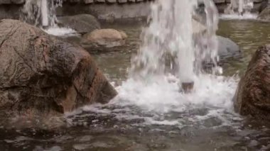 Büyük kahverengi ıslak taşlar ve su boruları Çeşme üzerinden spurting streams