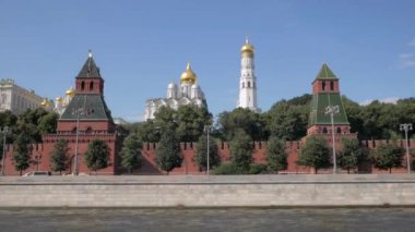 Moskova Nehri Dolgu ile kırmızı tuğla Kremlin duvarları kuleleri ve yeşil ağaçlar ve güzel beyaz katedraller, Moskova, Rusya mavi gökyüzü karşı altın kubbe ile geçmiş hareketli beyaz turist tekne