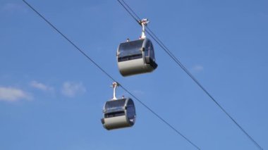 Close up of two cable road cabins slowly moving apart in the air