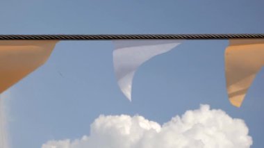 Festival bayrak mavi gökyüzü ve beyaz kabarık bulutlar karşı kiraz kuşu uçmaktan yakın çekim