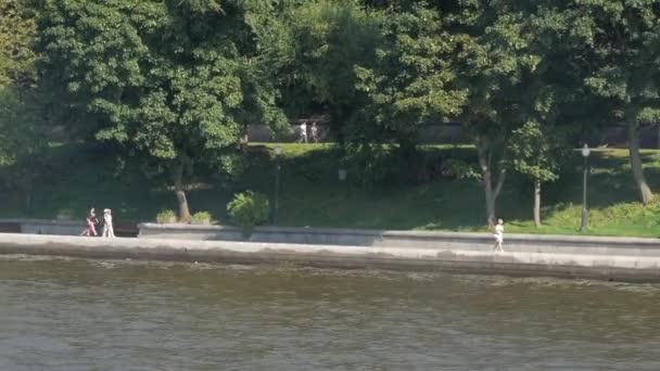 夏の日の美しい川の堤防を歩いてリラックスした人々 — ストック動画