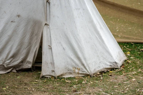 Detail of dirty medieval canvas tent standing on grass