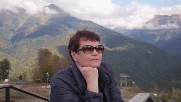 Mulher Sênior Óculos Sol Frente Montanhas Cobertas Florestas Olhando Para — Vídeo de Stock