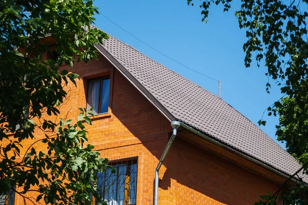 Rotes Backsteinhaus mit Drainage und dekorativen Fenstergittern — Stockfoto