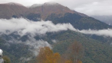 Sochi, Rosa Khutor, Rusya Federasyonu - 14 Ekim 2017: kar topu önünde bulutlar ve sis kaplı güzel yeşil ve sarı Dağları yakın çekim. Atış kaydırma