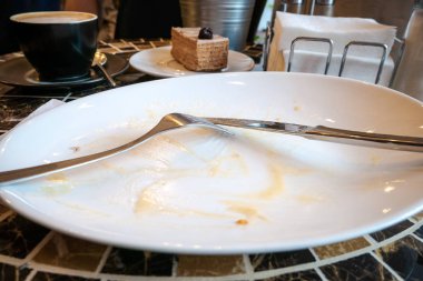 Boş kirli tabak çatal ve bıçak masanın üzerine bıraktı