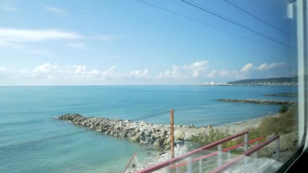 明るい夏の日の青空 ターコイズ ブルーの海 防波堤 を見下ろす車窓からの美しい眺め — ストック動画