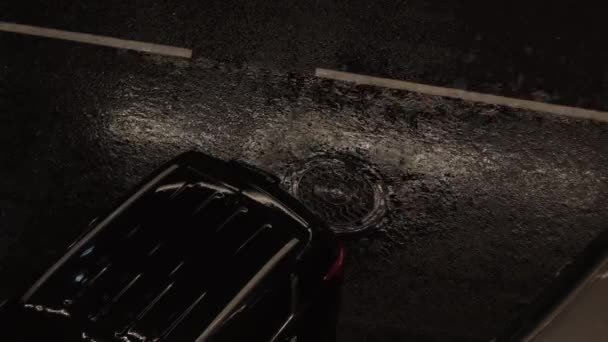 重い夜雨の音と暗闇の中で黒い車とアスファルト道路の土砂降り ハイアングル — ストック動画