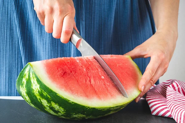 Female hands cutting ripe watermelon — Stock Photo, Image