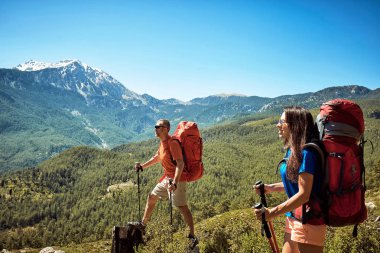 Yaz aylarında kırmızı bir sırt çantası ile yüksek dağlarda yürüyüş.