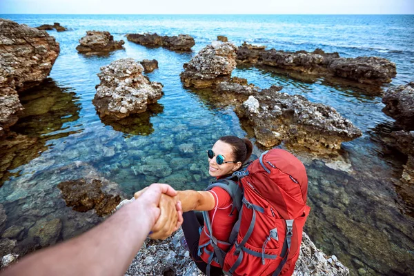 A helping hand on the seaside in a summer hike.