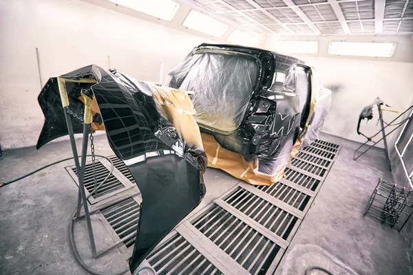 Painting the car in black color in the paint chamber on the service