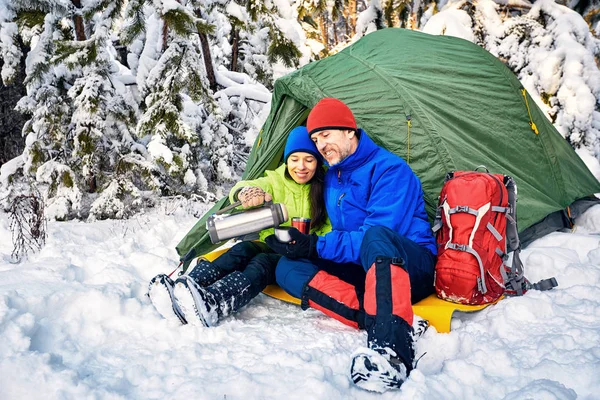 Camping in the winter forest of a couple in love.