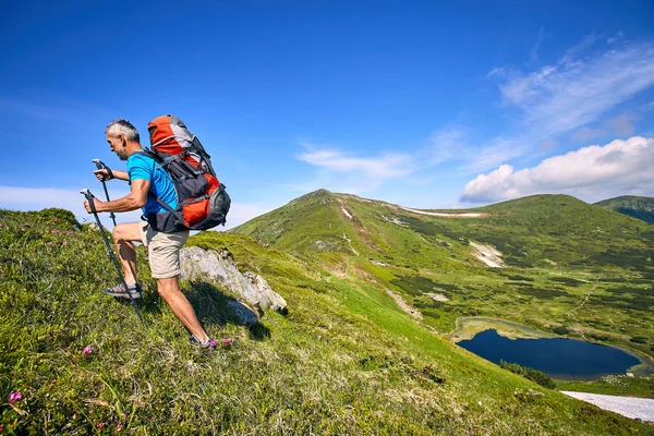 トップにバックパックとパスに沿ってテント山で夏のハイキング ロイヤリティフリーのストック画像