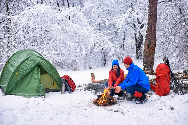 Camping in the winter forest of a couple in love.