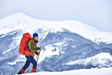 Kış trek yüksek bir sırt çantası ile dağlarda.