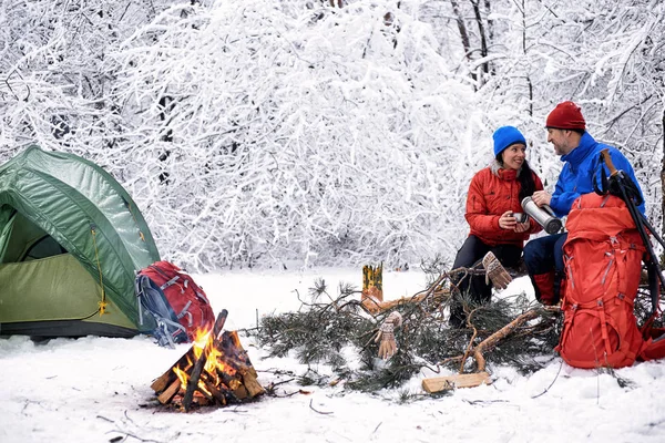 Camping in the winter forest of a couple in love.