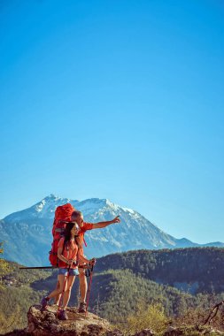 Yaz aylarında kırmızı bir sırt çantası ile yüksek dağlarda yürüyüş.