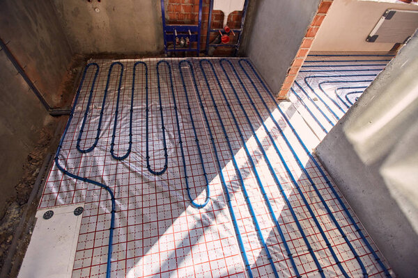 Laying pipes for floor heating at the construction site of the house