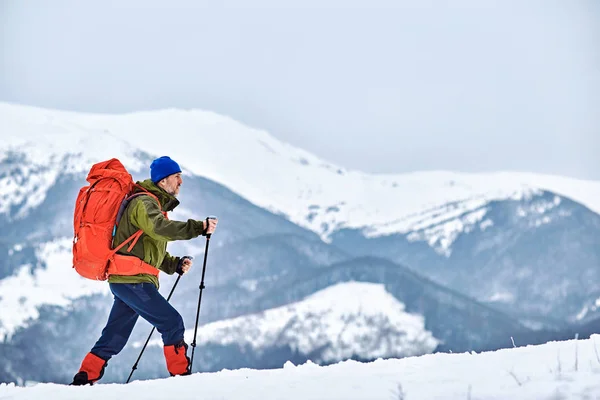Winter klim naar de top van de berg met een rugzak. — Stockfoto