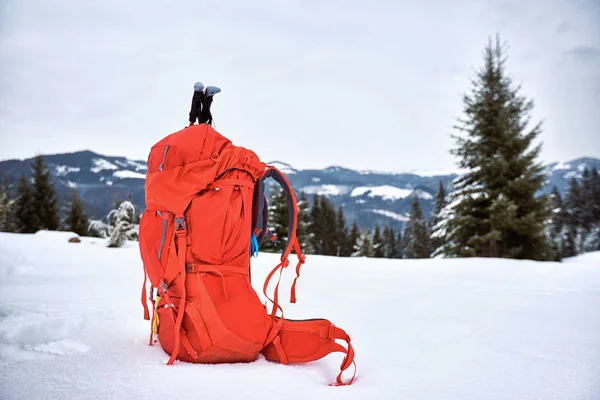 Ein roter Rucksack im Schnee bei einer Winterkampagne gegen den Rücken — Stockfoto