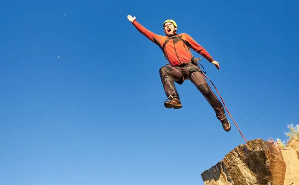 Saltar la cuerda de una roca alta en las montañas . — Foto de Stock