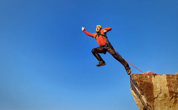 Saltar la cuerda de una roca alta en las montañas . — Foto de Stock