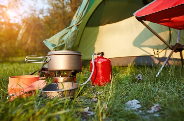 Camping en el bosque con una mochila y una tienda de campaña a orillas del — Foto de Stock