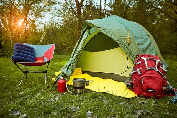 Camping en el bosque con una mochila y una tienda de campaña a orillas del — Foto de Stock