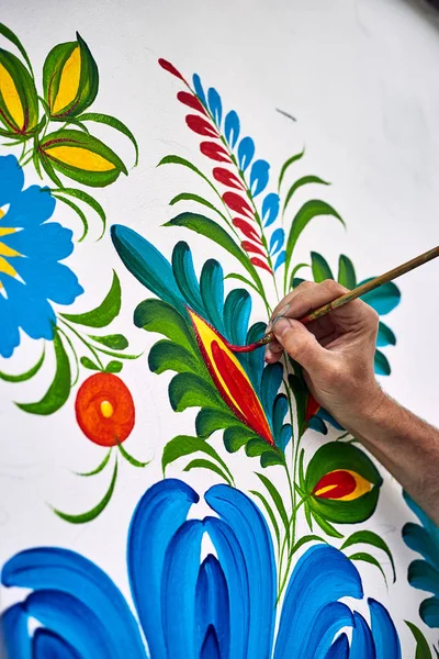 The artist paints with oil paints on a white wall. — Stock Photo, Image