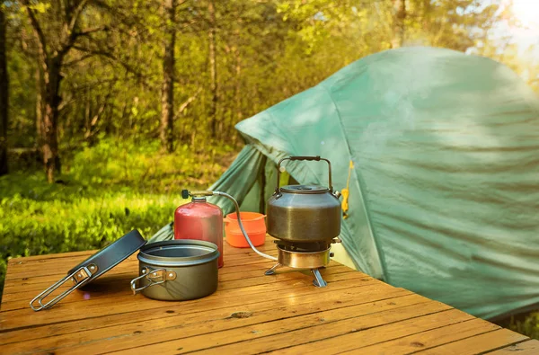 Camping in the woods with a backpack and a tent on the banks of