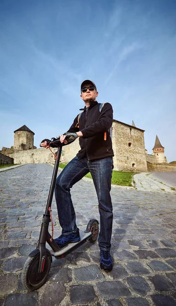 Um homem monta uma scooter no campo no verão . — Fotografia de Stock