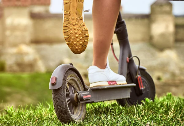 Menina montando uma scooter no campo no verão . — Fotografia de Stock