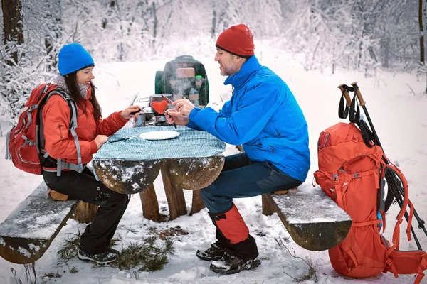 Preparando a refeição na caminhada de inverno na mesa no acampamento — Fotografia de Stock