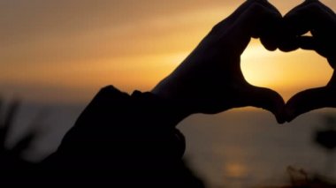 Yapma kalp şekli günbatımı - el ile kapatmak