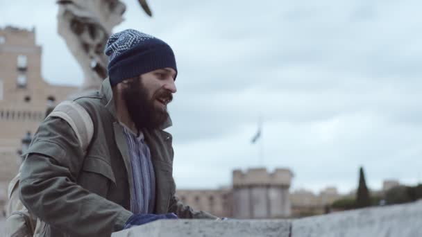 幸せなホームレスの男が橋から外を見て誰かを迎える — ストック動画
