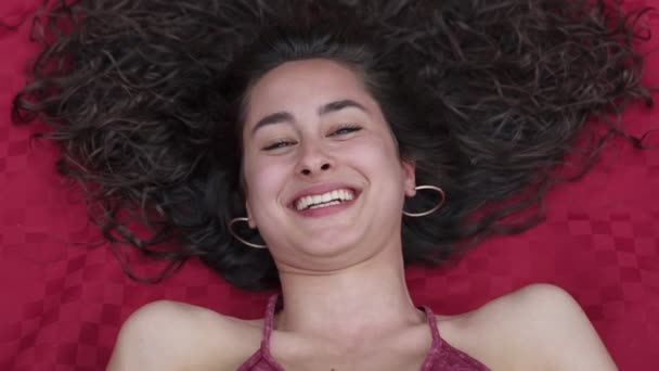 Крупним Планом Портрет Красивої Молодої Брюнетки Лежить Посміхаючись Камеру — стокове відео