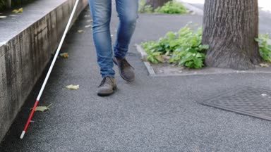 Bastonu ile sokakta yürüyen kör adam