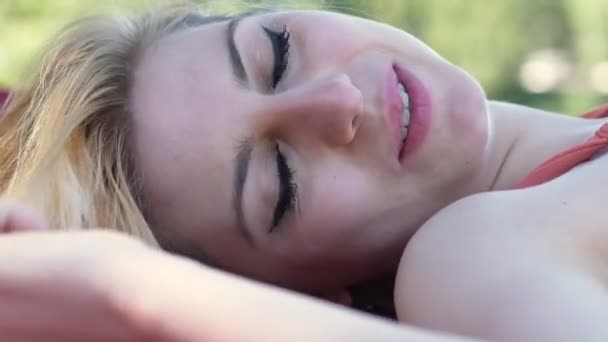 Νέοι Όμορφη Happy Ξανθιά Γυναίκα Ξαπλωμένη Στο Πάρκο Φλερτάρει Κάμερα — Αρχείο Βίντεο