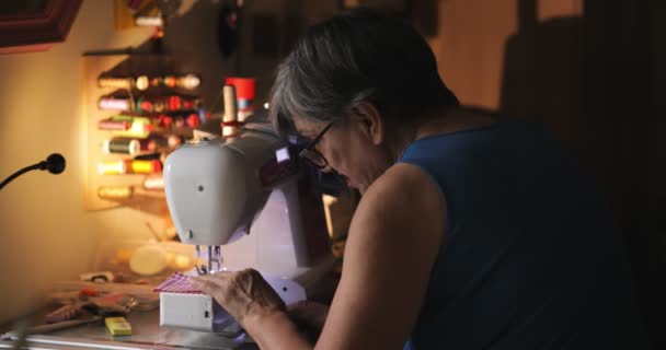 Ηλικιωμένη Γυναίκα Χρησιμοποιεί Ράβοντας Μηχανή Στο Σκοτάδι — Αρχείο Βίντεο