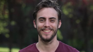 parkta kameraya gülümseyen güzel genç adamın portresi