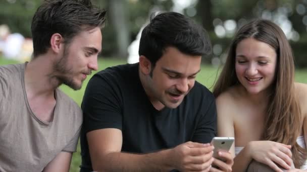 Grupo Amigos Parque Riendo Mirando Teléfono Inteligente — Vídeos de Stock